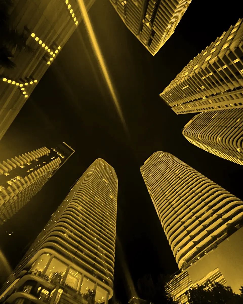 Looking straight up between two towers at night
