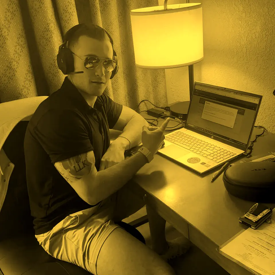 Headset on, laptop open at a hotel desk