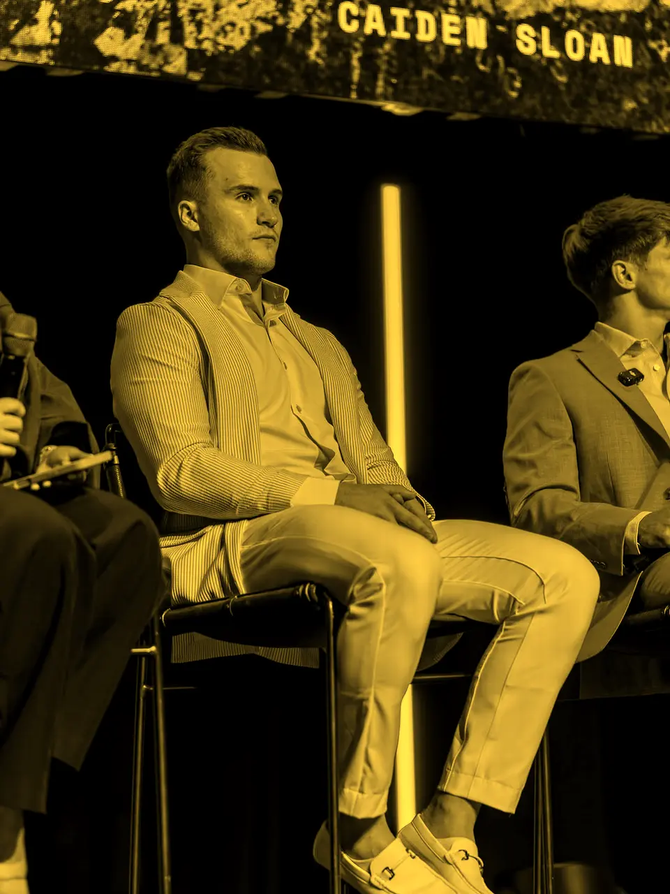 Caiden Sloan seated on stage under his name on the screen